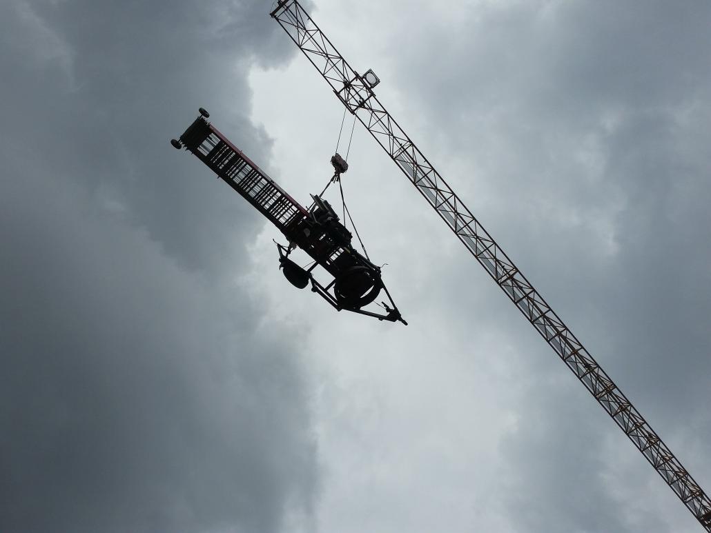 ein Schrägaufzug wird durch ein Baukran transportiert